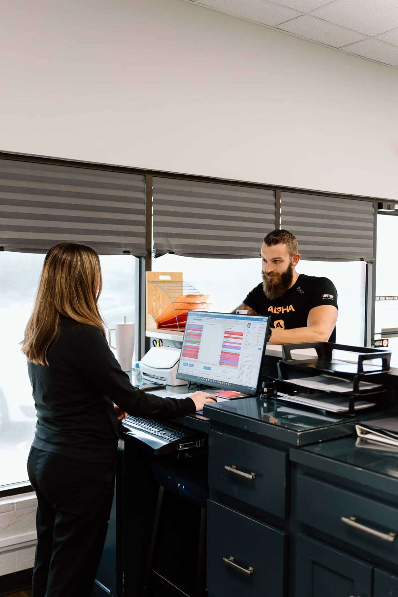 Chiropractor and staff member working at reception desk