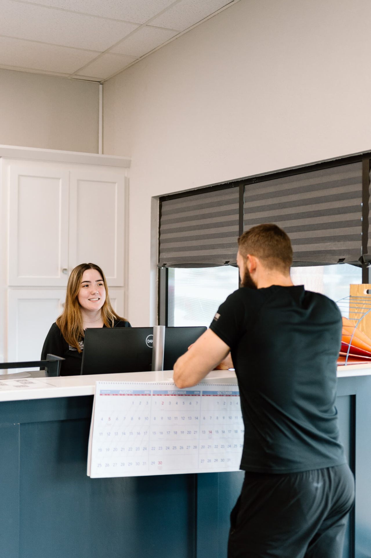 Friendly receptionist welcoming patient at chiropractic office