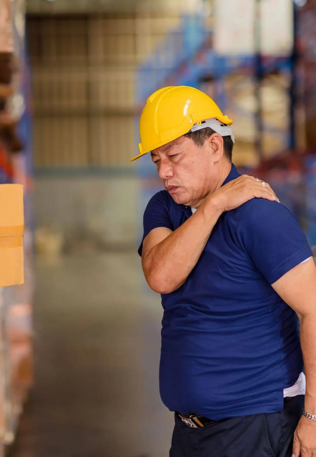 Worker in hard hat with neck pain injury