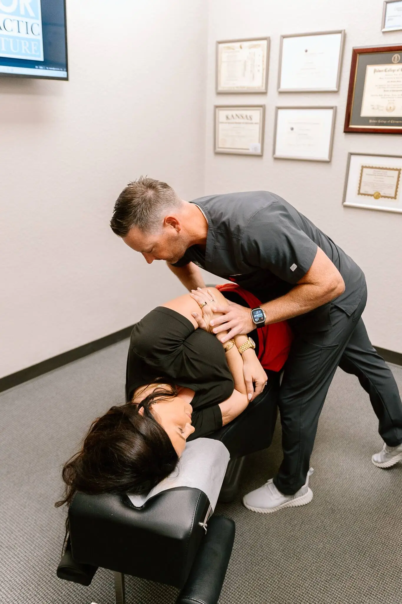 Dr. Meylor performing a hands-on chiropractic adjustment in the treatment room at the Lenexa office