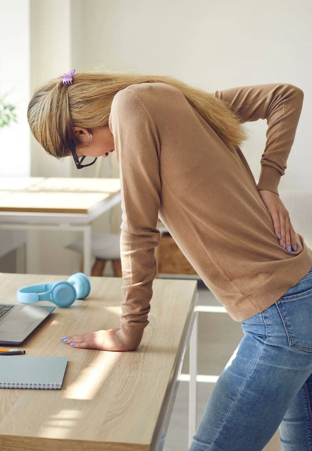 Woman experiencing back pain at work